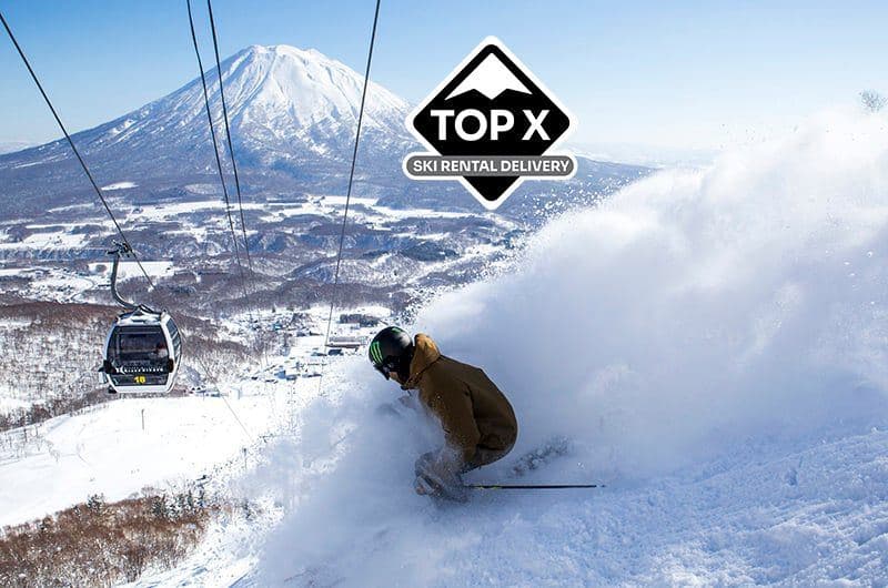 羊蹄山を背にパウダーを滑るスキーヤー